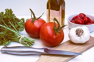 Mediterran Kochen in Olsberg Kräuter, Tomaten, Öl und Knoblauch auf einer Arbeitsfläche